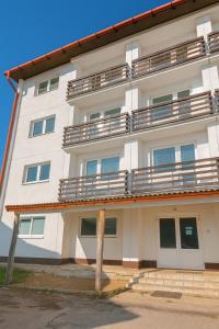 a white building with balconies on the side of it at Apartmán 13 in Otilia