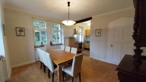 a dining room with a wooden table and white chairs at Forsthaus Hausbach - Ferienwohnung Hirsch in Losheim