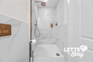 een badkamer met douche en witte marmeren muren bij The Old Schoolhouse in Leeds