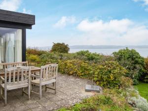 a patio with two wooden chairs and a table at 6 person holiday home in Børkop-By Traum in Børkop
