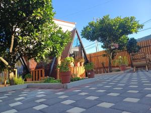 a patio with trees and potted plants on a house at Guest House Adilaj in Berat
