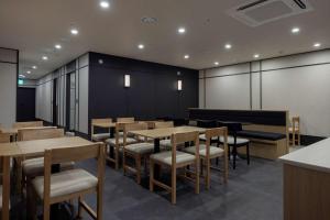 a dining room with wooden tables and chairs at Mitasuya Ryokan Hotel Daejeon Yuseong in Daejeon