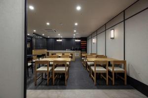a dining room with wooden tables and chairs at Mitasuya Ryokan Hotel Daejeon Yuseong in Daejeon