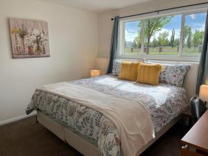 a bedroom with a bed with a window at 3 Adjacent 4-bed Homes - Park Views, Fully Stocked in Grande Prairie