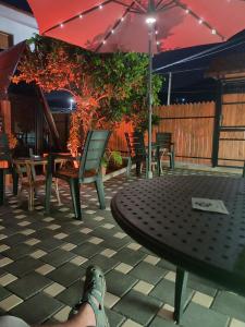 a person with their feet up on a table with an umbrella at Guest House Adilaj in Berat