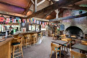a bar with tables and chairs in a restaurant at Insolites, Les Ormes, Epiniac in Epiniac