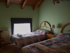 a bedroom with two beds and a window at Casa Miguel Périz in Sorripas