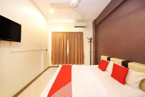 a room with a bed with red pillows and a tv at Hotel O Batu Ferringhi Beach formerly ESQ Ferringhi in Batu Ferringhi +48 photos