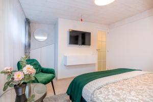 - une chambre avec un lit, une chaise et une télévision dans l'établissement Žalia kopa near the beach apartments, à Palanga 13 autres photos