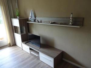 - un salon avec une étagère et une télévision dans l'établissement Ferienwohnung F239 für 2-4 Personen an der Ostsee, à Schönberg in Holstein