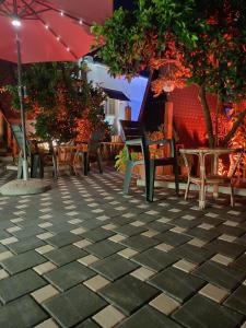 a patio with chairs and tables and an umbrella at Guest House Adilaj in Berat