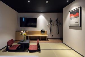 a living room with a table and chairs and a tv at Mitasuya Ryokan Hotel Daejeon Yuseong in Daejeon