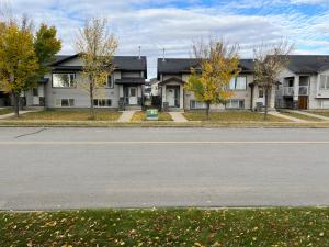 an empty street in front of a house at 3 Adjacent 4-bed Homes - Park Views, Fully Stocked in Grande Prairie