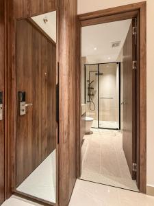 a bathroom with wooden walls and a glass door at Hygge Haven Saigon in Ho Chi Minh City
