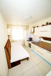 a white kitchen with a bed and a counter at Квартира посуточно двокімнатна у мікрорайоні Садовий Мережа Alex Apartments Документи для відряджень ФОП 3 група in Poltava