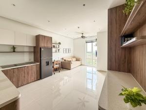 a kitchen and living room with a refrigerator and a couch at Hygge Haven Saigon in Ho Chi Minh City