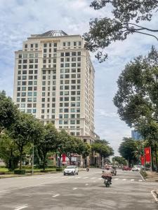 a large building on a city street with a motorcycle at Hygge Haven Saigon in Ho Chi Minh City
