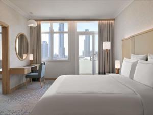 a hotel room with a large bed and a desk at Swissôtel Al Murooj Dubai in Dubai +195 photos