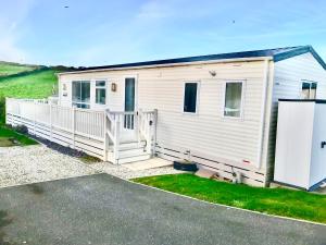 a white tiny house with a large porch at Beautiful durdle door holiday park in West Lulworth