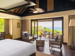 a bedroom with a bed and a patio with a table at Raffles Bali in Jimbaran +158 photos
