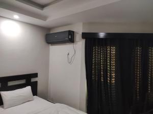 a bedroom with a bed and a television on the wall at Moon Living Apartment Peshawar in Peshawar