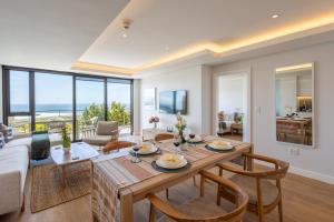 a living room with a table and chairs and a couch at Plett Quarter Apartments in Plettenberg Bay