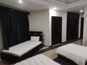 two beds in a room with two beds sidx sidx sidx at Moon Living Apartment Peshawar in Peshawar
