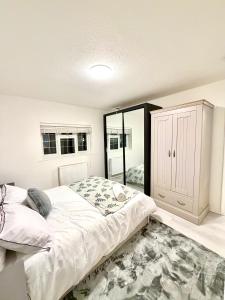a bedroom with a large bed and a mirror at 4 Bedroom House CheapUKholiday in Dagenham