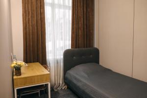 a bedroom with a bed and a desk and a window at Summit Villa in Chişinău