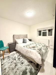 a bedroom with a large bed and a rug at 4 Bedroom House CheapUKholiday in Dagenham
