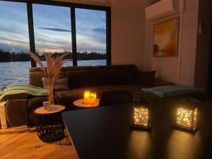 a living room with a couch and a table with candles at Hausboot Mit Sauna in Braunsbedra