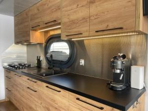 a kitchen with wooden cabinets and a counter top at Hausboot Mit Sauna in Braunsbedra +10 photos