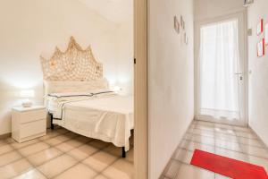 een slaapkamer met een bed en een groot raam bij Appartamento Corallo in Porto Cesareo