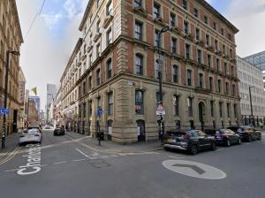 a large building with cars parked in front of it at Hidden Gem of City Center in Manchester