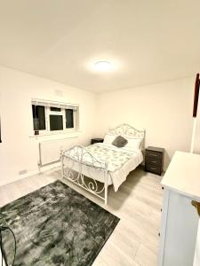 a bedroom with a white bed and a rug at 4 Bedroom House CheapUKholiday in Dagenham