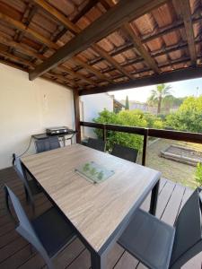 a wooden table and chairs on a deck at Villa de l'oustaoun in Sanary-sur-Mer