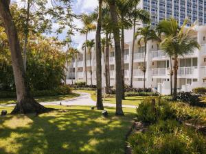 ein großes weißes Gebäude mit Palmen davor in der Unterkunft Fairmont El San Juan Hotel in San Juan