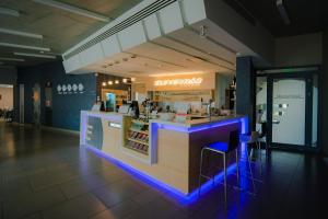 a restaurant with a bar with blue lights at Eleven Business & Sport Hotel in Jászárokszállás