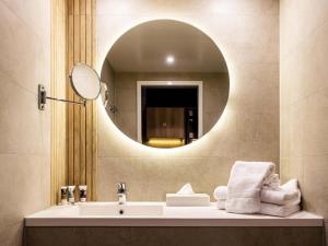 a bathroom with a sink and a mirror at Mercure Han-sur-Lesse in Han-sur-Lesse +102 photos