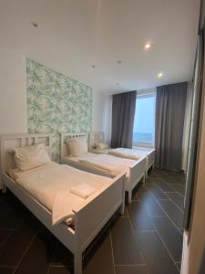 a room with three beds and a large window at The Greenstead in Hannover