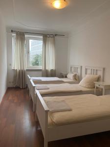 a row of beds in a room with a window at The Greenstead in Hannover