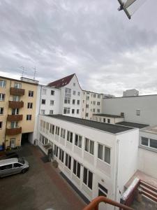 a white building with a car parked in front of buildings at The Greenstead in Hannover