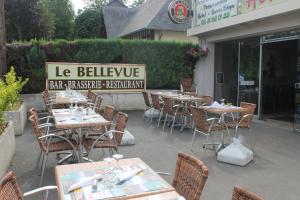 a group of tables and chairs in front of a restaurant at Le Bellevue Lisieux in Lisieux