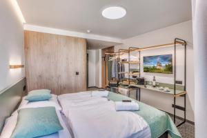 a bedroom with two beds and a desk at STEELHOUSE Hotel in Třinec +27 photos