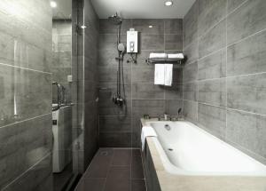 a bathroom with a bath tub and a shower at CASA by Meridian in Phnom Penh +11 photos