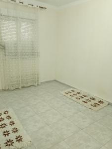 une chambre avec deux tapis à l'étage, à côté d'une fenêtre dans l'établissement MDN location, à Alger