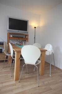 a living room with a table with chairs and a television at ÜbermTal in Schmallenberg