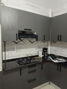 une cuisine avec des armoires blanches et un four à plaques de cuisson dans l'établissement MDN location, à Alger