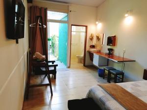 a bedroom with a bed and a desk and a bathroom at Green Lodge in Florianópolis