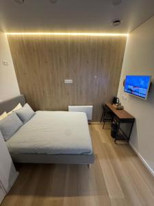 a bedroom with a bed and a desk and a television at 12 New Airport Apartment in Pakopi